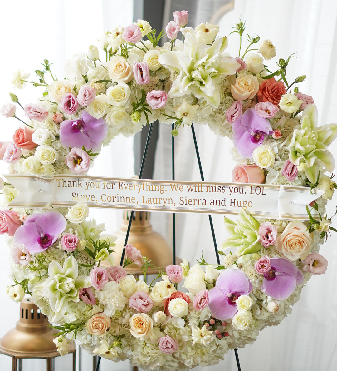 Floral wreath with pink and purple flowers and a white ribbon with text.Funeral and Sympathy Flowers Delivery Toronto