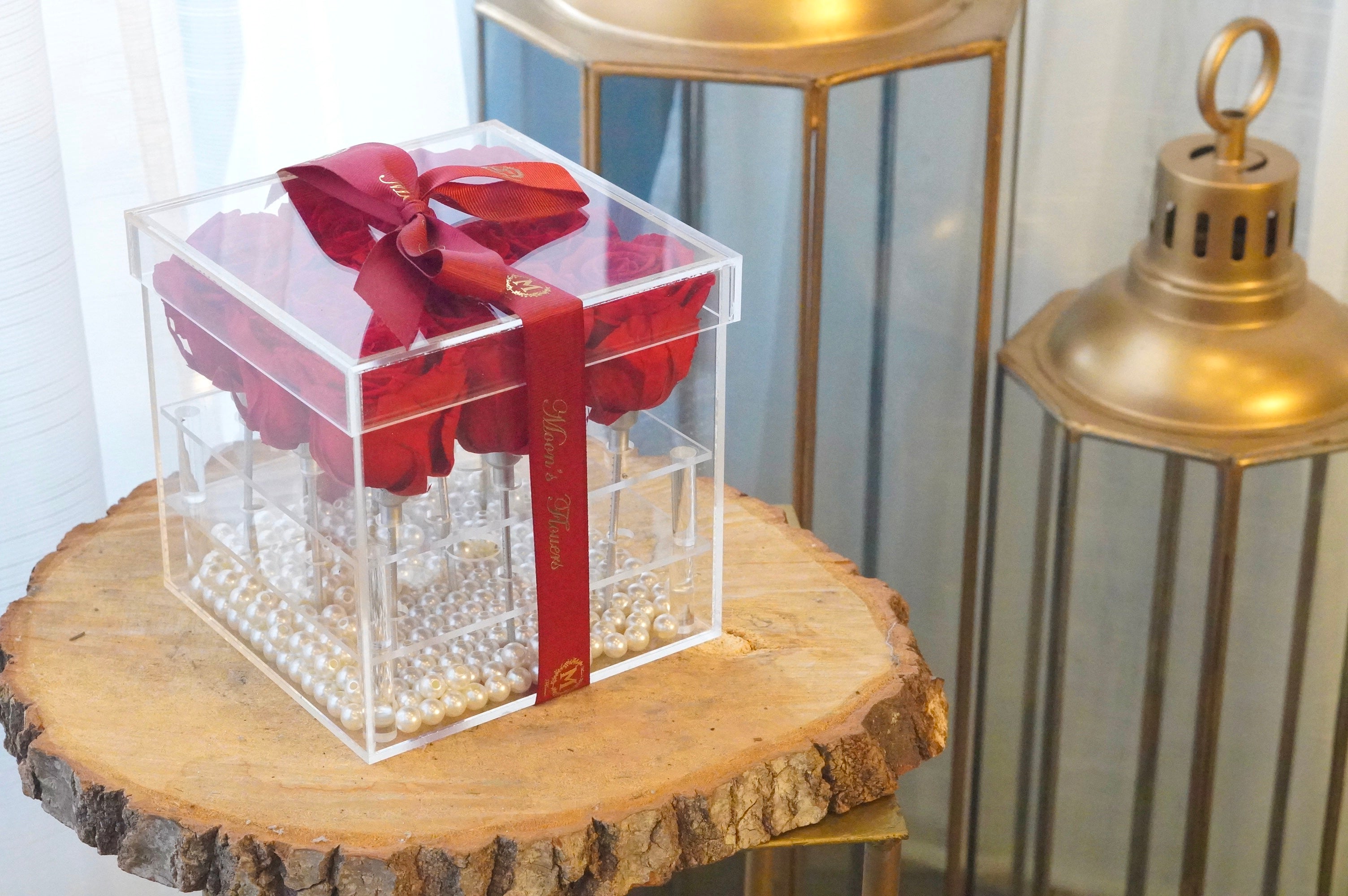 This image shows the product Preserved Rose in Acrylic Box. It has pearls on the bottom of the box and is clear to see the roses at all angles