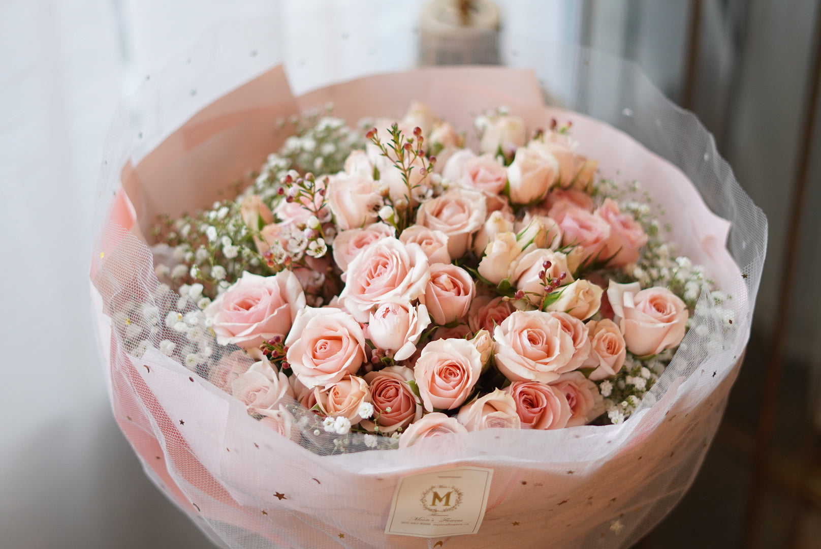 Close-up of delicate pink spray roses and baby’s breath bouquet with soft romantic details