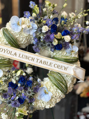 Side view of a 25-inch funeral wreath featuring blue accents and fresh seasonal greenery