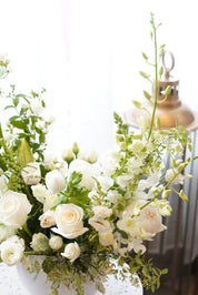 Sincere sympathy white floral tribute featuring lush greenery and seasonal white blooms.