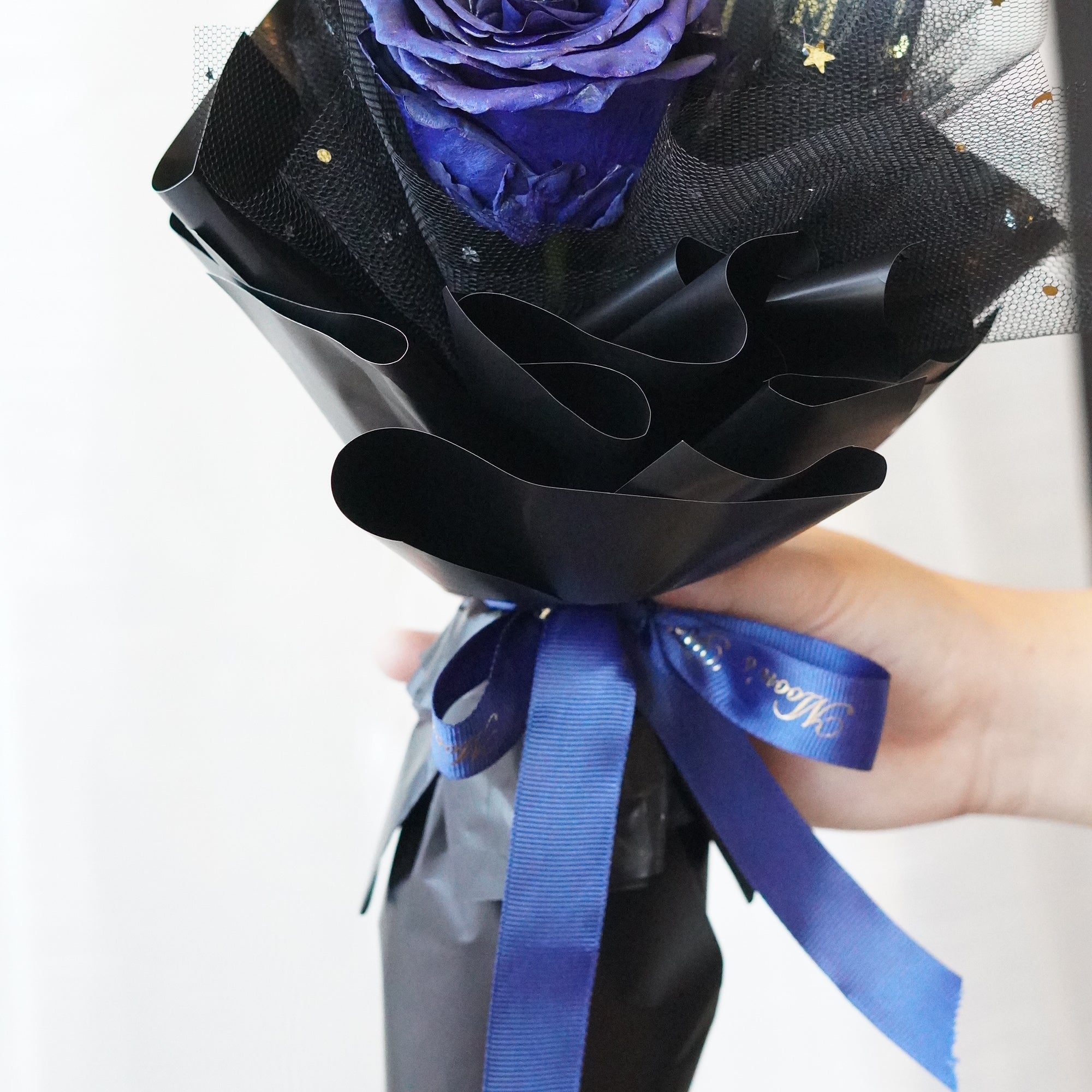 Long stem blue rose wrapped in Moon’s Flowers’ signature packaging