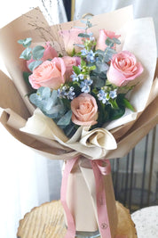 Sky blush rose bouquet featuring soft pink roses with blue accent flowers and fresh greenery