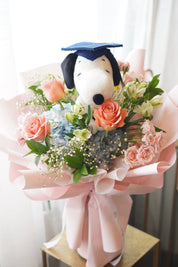 Snoopy graduation bouquet with peach roses and blue hydrangea, soft pink wrapping, Toronto flower delivery