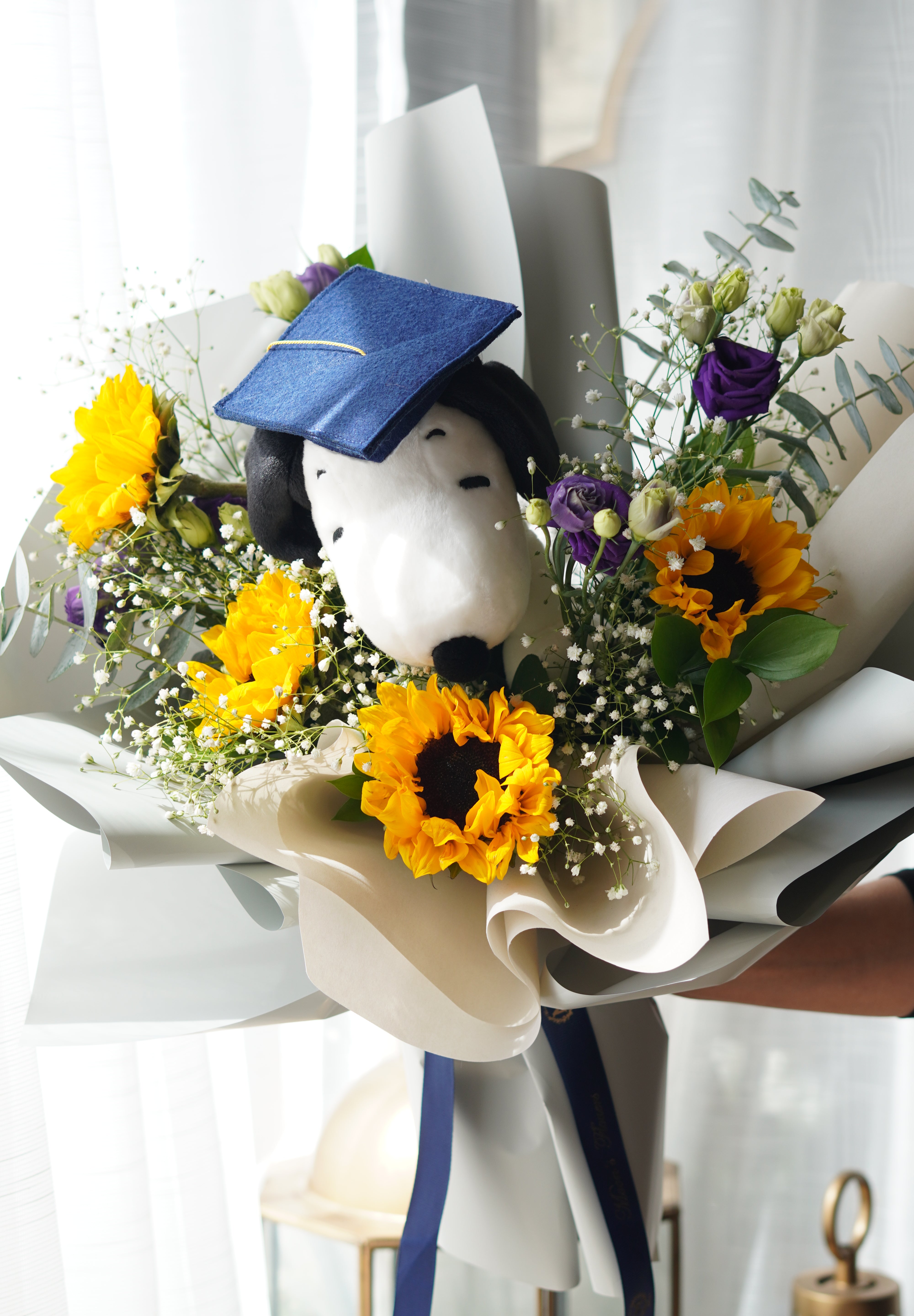 Snoopy graduation bouquet with sunflowers, baby’s breath, and purple flowers, hand-held bouquet