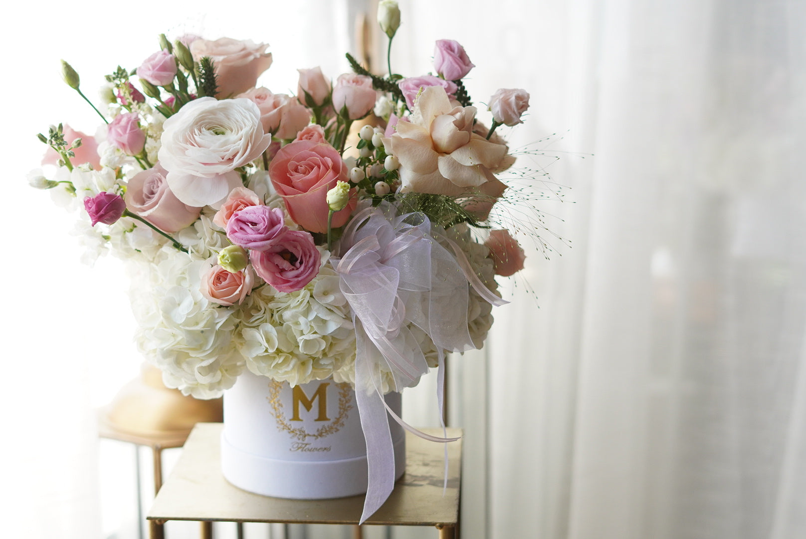Soft blush and ivory flower arrangement in hat box with garden style flowers – Moon’s Flowers Toronto