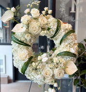 Standing  funeral wreath with white roses, hydrangeas, and lilies on a florist easel for same-day delivery in Toronto
