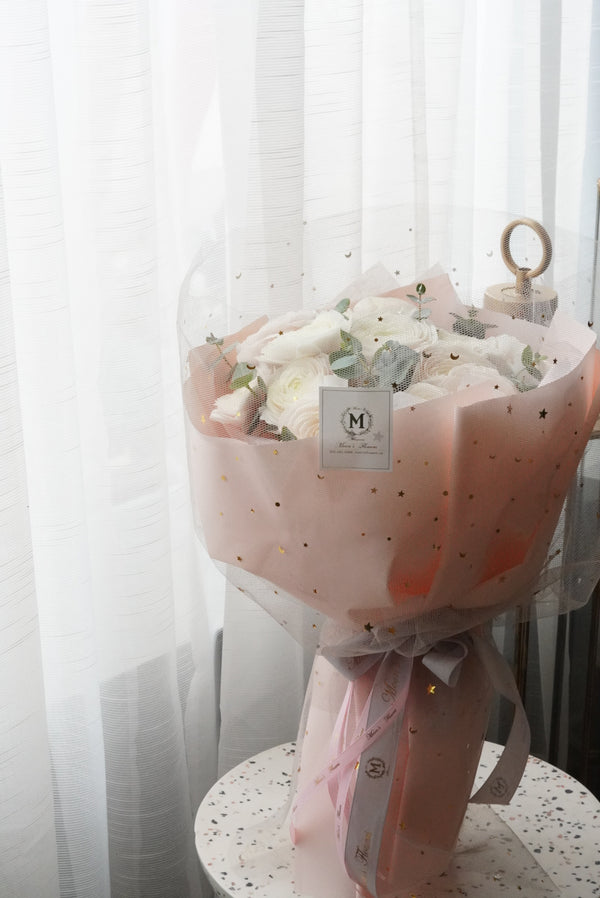 Luxury white ranunculus bouquet with star dotted pink wrapping paper. premium floral design by Moon's Flowers. Available for fast flower delivery in Oakville, Toronto, and the GTA-ideal for unique birthday or Mother's day gift 
