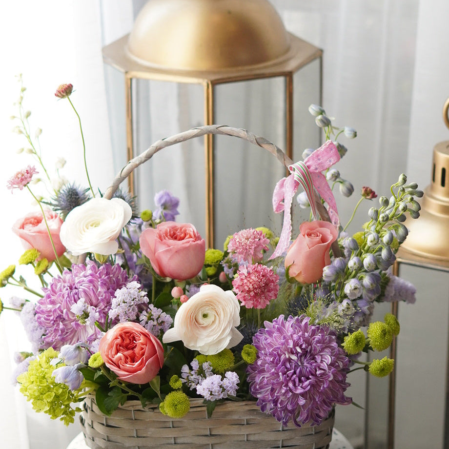 pastel flower basket arrangement with roses, ranunculus and hydrangea in white woven basket Toronto