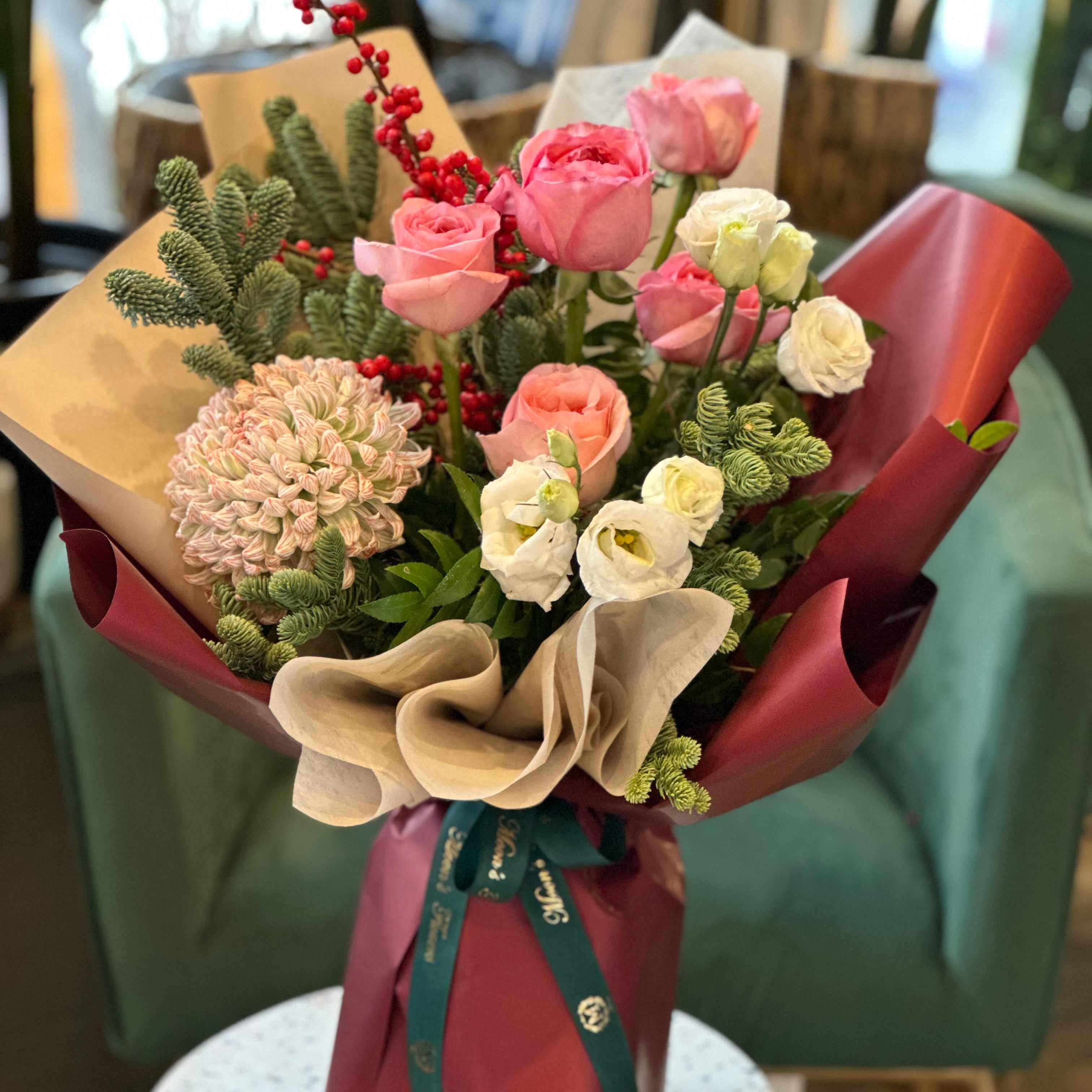 Winter Bouquet has Pink roses, chrysanthemum, winter greens and more to create a full and winter speicifc handtied bouquet. 