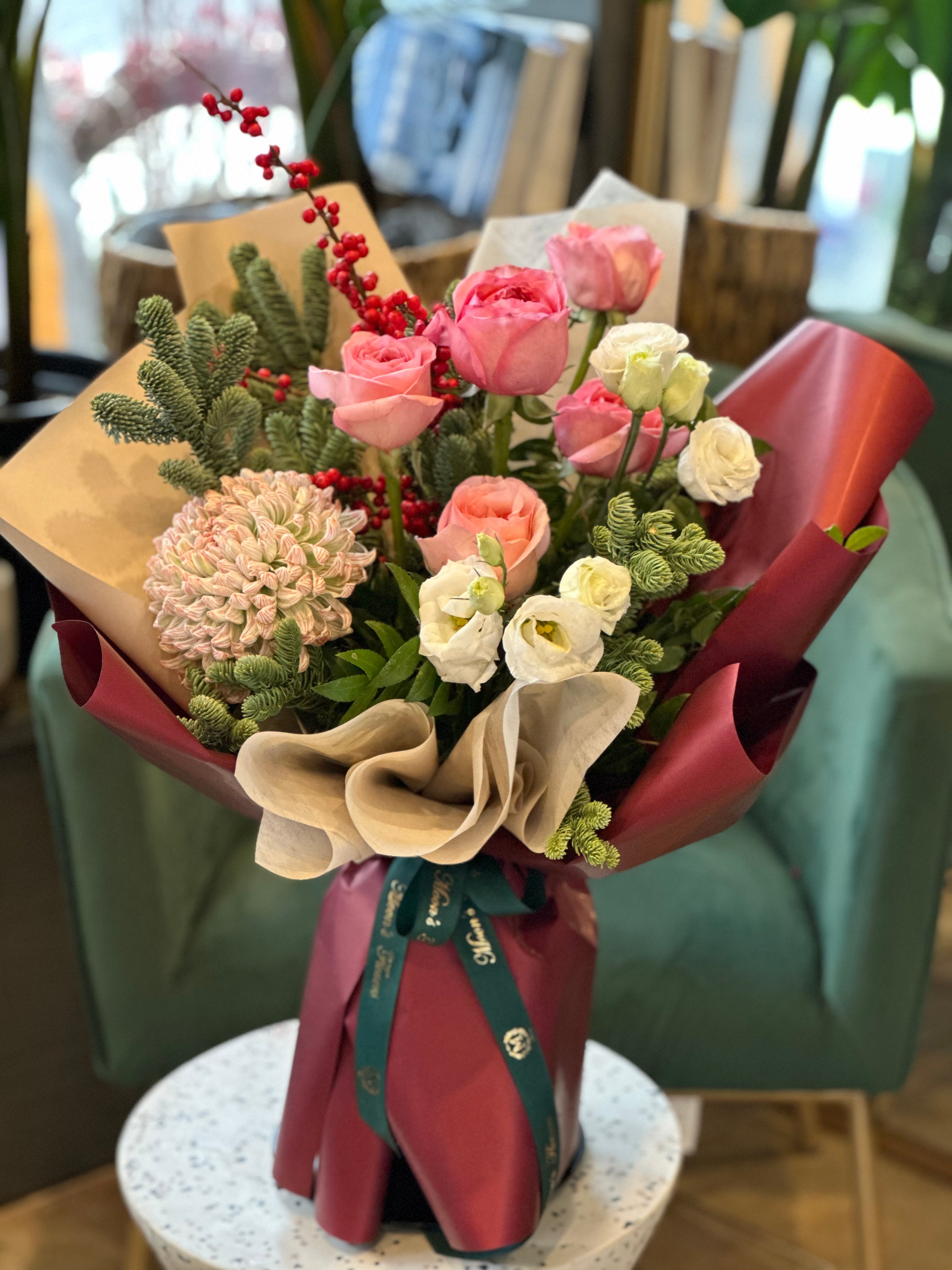 Winter Bouquet has Pink roses, chrysanthemum, winter greens and more to create a full and winter speicifc handtied bouquet. 