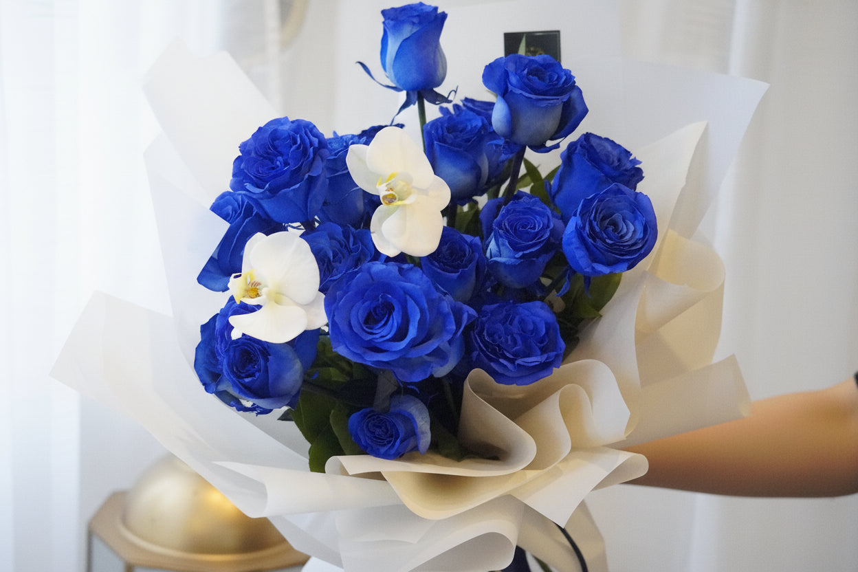  blue rose bouquet with white orchid and natural greenery
