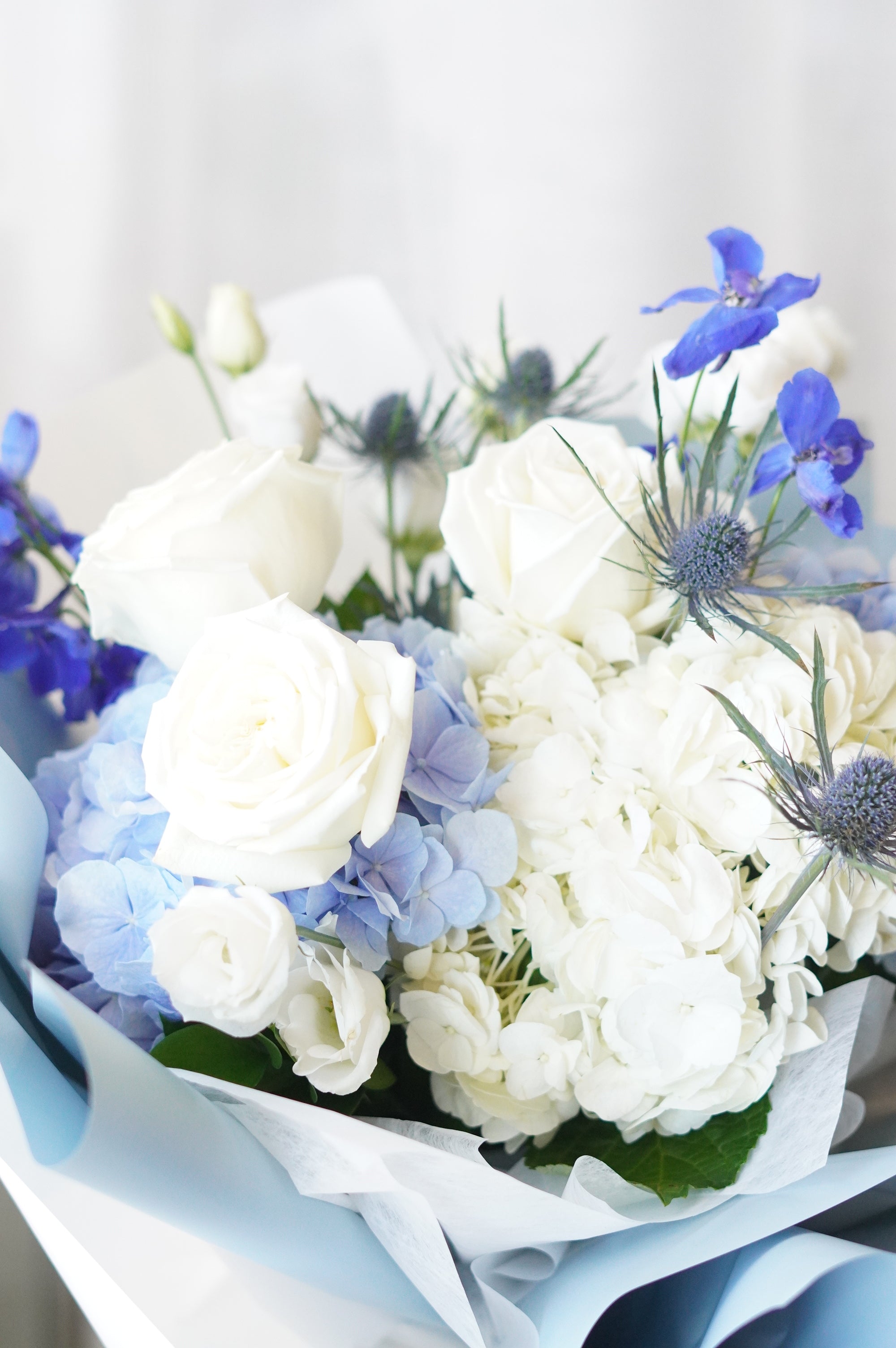 The "Frozen Blooms" bouquet from Moon's Flowers, featuring a winter-inspired color palette of blue and white hydrangeas with white roses