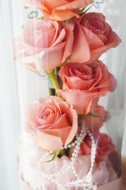 tanghulu rose bouquet close-up with vertically arranged roses inside clear acrylic wrap with pearl detail