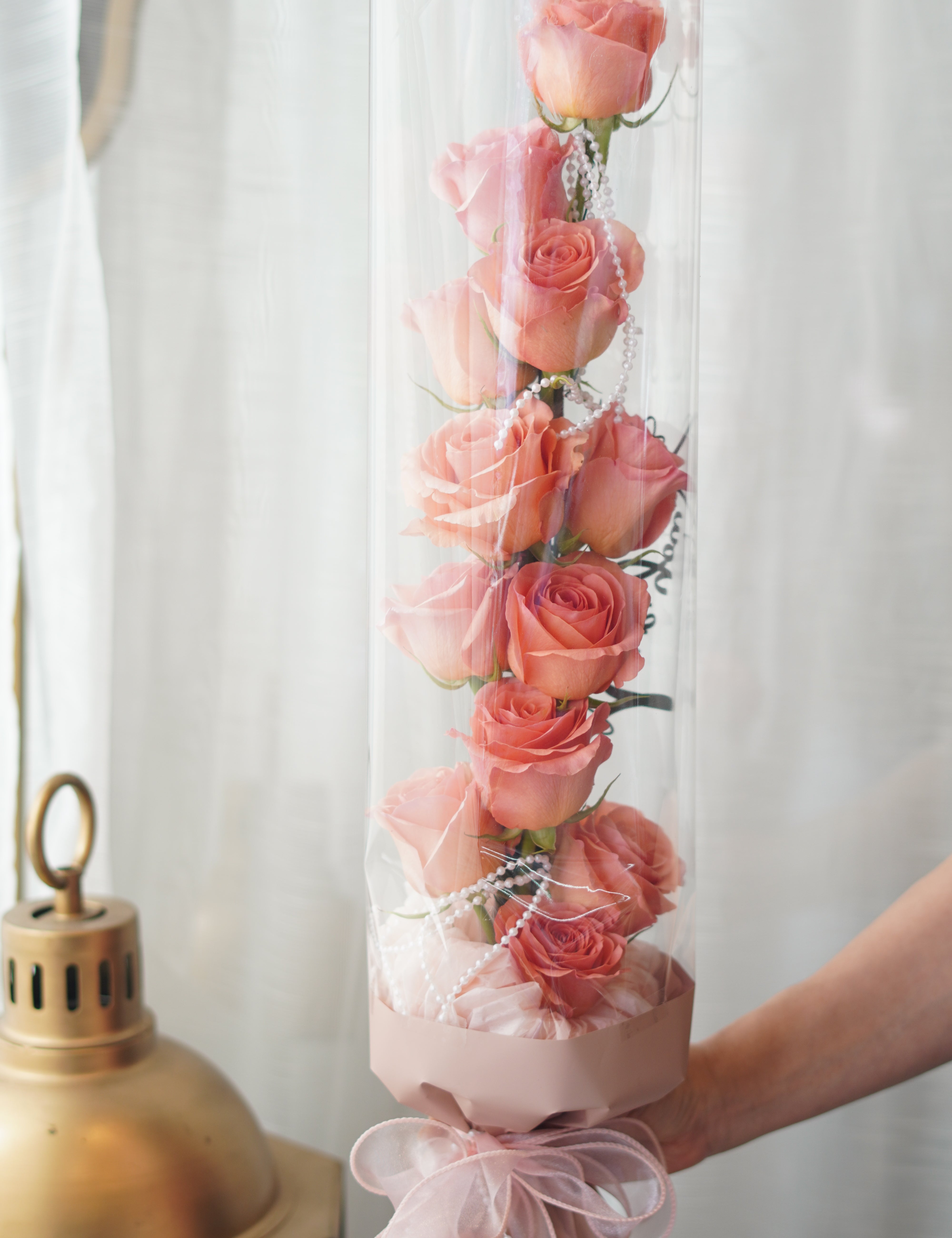 vertical rose bouquet in tanghulu style with neatly arranged roses inside transparent wrapping