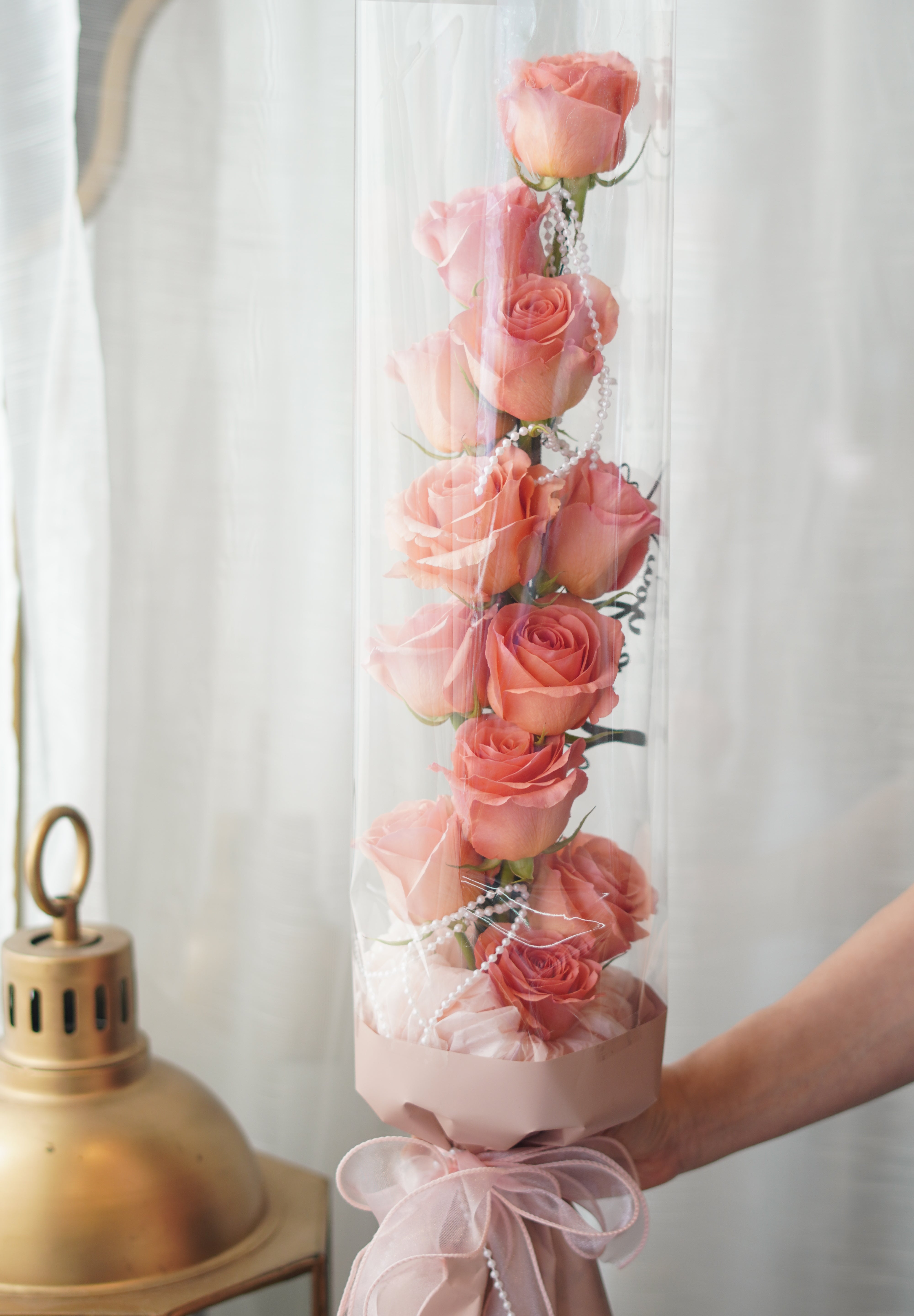 vertical rose bouquet in tanghulu style with neatly arranged roses inside transparent wrapping