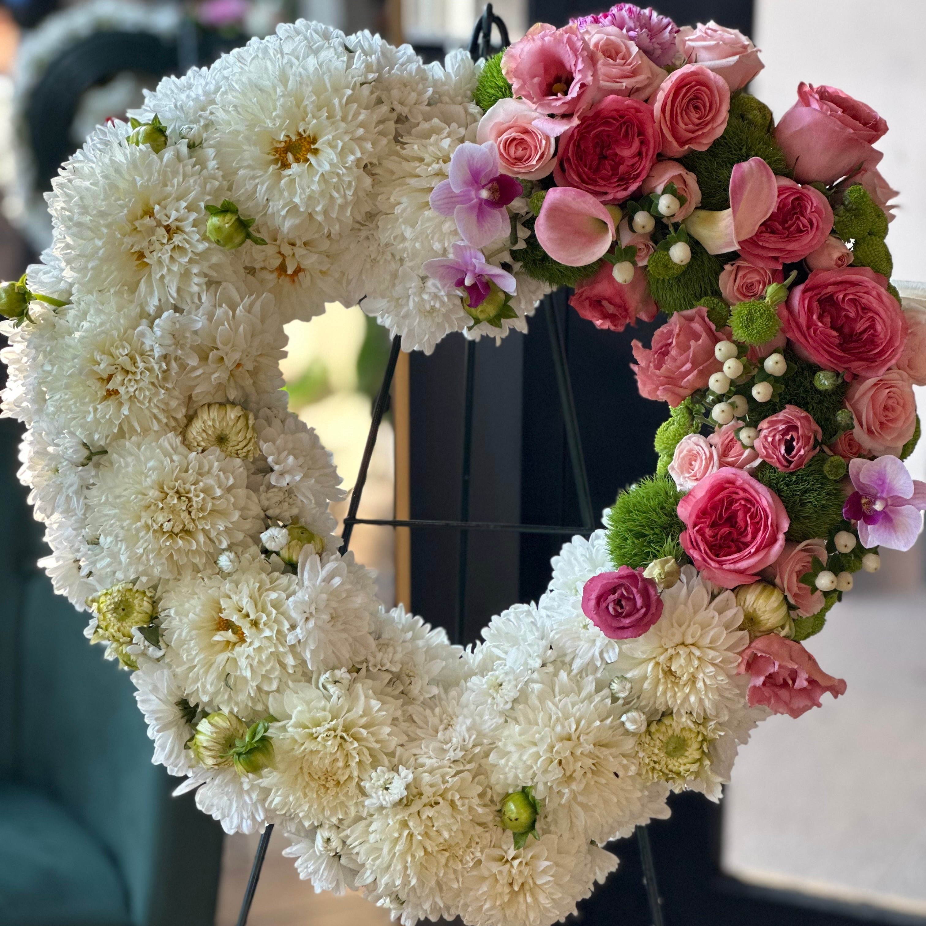 Detailed view of a white and red sympathy heart wreath for funeral services in Toronto.