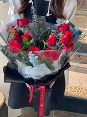 Heart-shaped rose bouquet held by hand, wrapped in Moon’s Flowers’ signature style