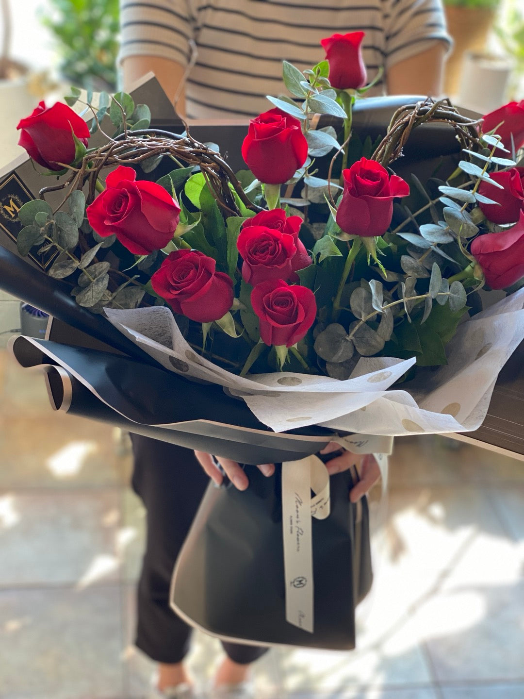 Full view of a heart-shaped rose bouquet held by hand for gifting