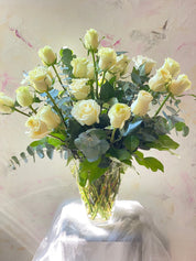 Two dozen white roses arranged in a vase