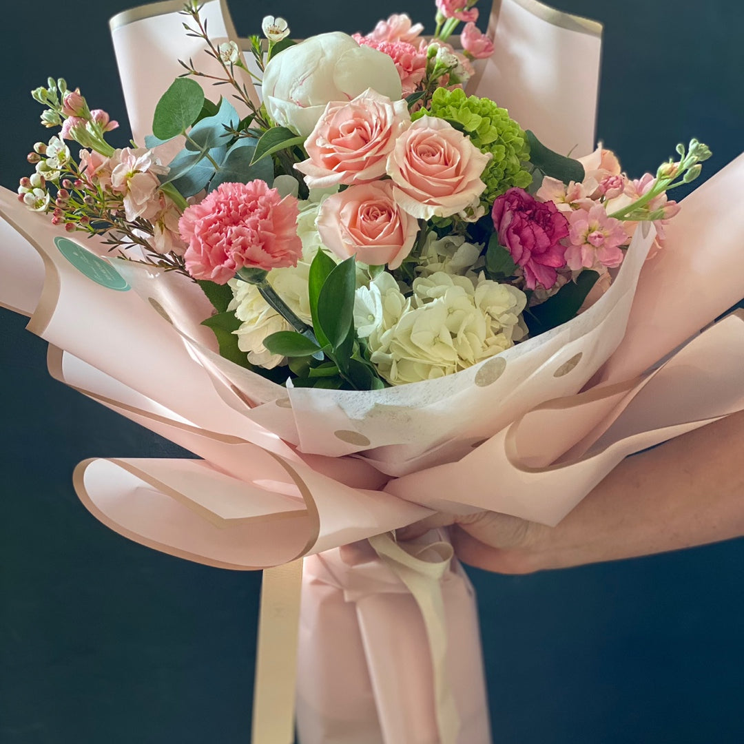 Deluxe size blush pink rose and white hydrangea bouquet wrapped in soft pink paper